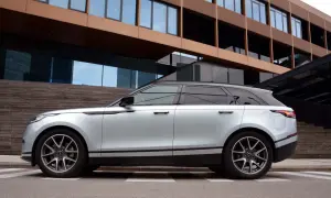 Silberner Range Rover Velar parkt vor moderner Architektur. Die eleganten Range Rover Velar Maße passen perfekt in das urbane Umfeld.