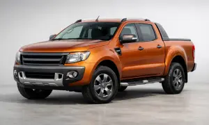 Orange Ford Ranger im Test. Der robuste Pickup steht auf einem grauen Untergrund vor hellem Hintergrund.