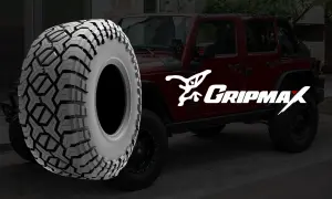 Ein grobstolliger Reifen von Gripmax neben einem roten Jeep. Perfekt für jedes Abenteuer.