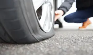 Ein Auto mit platten Reifen steht auf Asphalt. Die Frage ist, wie lange kann ein Auto auf einem platten Reifen stehen, bevor es beschädigt wird?