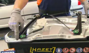 Kfz-Mechaniker lernt Fensterheber nach Batteriewechsel an. Einbau eines neuen Fensterhebersystems.