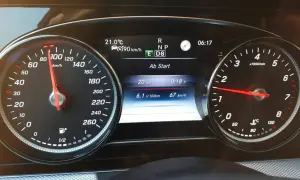 Fahrzeug-Display eines Mercedes mit Tacho bei 90 km/h, Verbrauchsanzeige und aktiver Tempomat-Funktion.