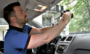 Mann montiert eine Dashcam im Auto. So kann er seine Fahrten aufzeichnen und sein Fahrzeug nachrüsten.