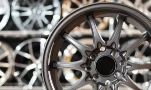 Graue Felge im Vordergrund, im Hintergrund weitere Felgen. Informiere dich über die felgen eintragen lassen kosten, um dein Auto aufzuwerten.