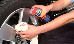 Person reinigt Felgen mit WD-40 und Tuch. Ein Hausmittel, das oft für felgen reinigen hausmittel verwendet wird.