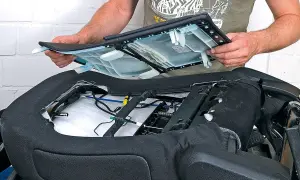 Ein Mann montiert eine Sitzfläche, um die Sitzheizung nachrüsten zu können. Die Kosten dafür sind überschaubar.