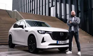 Mann steht neben weißem Mazda CX-60. Der Wagen ist bereit für den Mazda CX-60 Test.