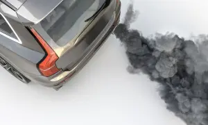 Graues Auto stößt dichten, schwarzen Rauch aus dem Auspuff aus.