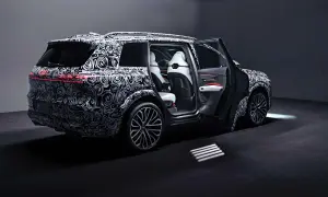Der Audi SQ9, getarnt mit einem auffälligen Muster, zeigt seine luxuriösen weißen Ledersitze und die sportlichen Felgen.