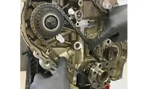 Hände prüfen die Steuerkette eines Motors. Die Frage, wie lange hält eine steuerkette, hängt von Wartung und Material ab.