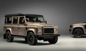 Zwei bronzefarbene Land Rover Defender stehen nebeneinander. Der vordere, klassische Defender ist bereit, wenn Sie einen Land Rover kaufen möchten.