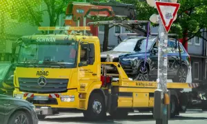 Gelber ADAC-Abschleppwagen mit SUV auf Ladefläche. Informiert über die Kosten eines Abschleppdienstes.