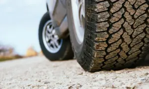 Detailaufnahme eines grobstolligen Offroadreifens, bereit für Abenteuer auf Schotterwegen.