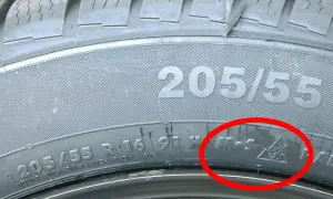 Detailaufnahme eines Reifens mit der Kennzeichnung 205/55 R16. Das alpine Zeichen (Schneeflocke im Berg) bestätigt, dass dies ein Winterreifen ist.