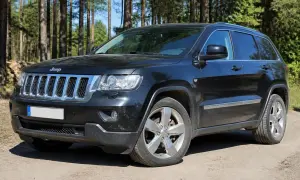 Schwarzer Jeep Grand Cherokee 3.6 V6 im Wald. Hoffentlich keine Probleme mit diesem Geländewagen.