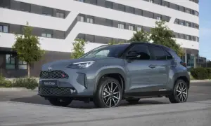 Grauer Toyota Yaris Cross 2026 mit GR-Sport-Akzenten steht vor einem modernen Gebäude.
