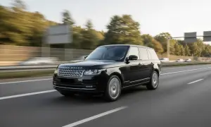 Schwarzer Range Rover fährt auf der Autobahn. Der kraftvolle Range Rover Motor surrt leise, während die Räder sich drehen.