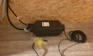 Einbau einer Standheizung: Das Gerät mit Kabeln liegt auf dem Boden, bereit für die Installation.
