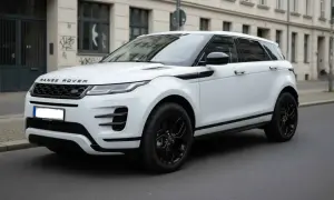 Ein weißer Range Rover klein mit schwarzen Felgen steht auf einer Straße vor einem Gebäude.