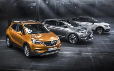 Drei Opel-Modelle in einem Parkhaus: ein orangefarbener Mokka, ein grauer Grandland X und ein weißer Crossland X. Ein Ausblick auf die Opel Modelle 2026.