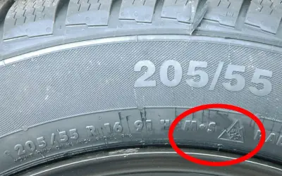 Detailaufnahme eines Reifens mit der Kennzeichnung 205/55 R16. Das alpine Zeichen (Schneeflocke im Berg) bestätigt, dass dies ein Winterreifen ist.