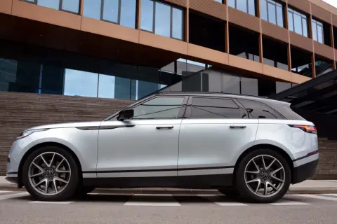 Silberner Range Rover Velar parkt vor moderner Architektur. Die eleganten Range Rover Velar Maße passen perfekt in das urbane Umfeld.