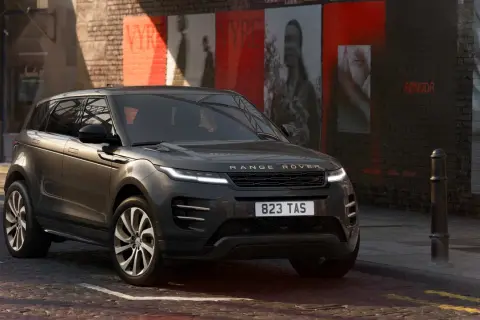 Dunkelgrauer Range Rover Evoque Black Edition parkt in einer Gasse mit Graffiti an der Wand.