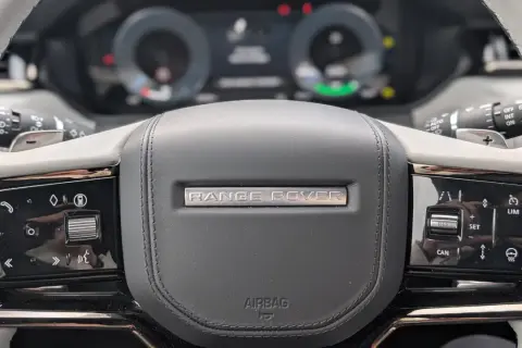 Nahaufnahme des **Range Rover Lenkrads** mit Bedienelementen für Tempomat und Infotainment.