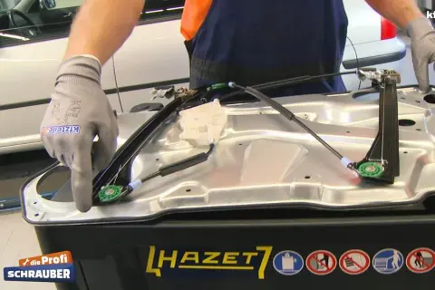 Kfz-Mechaniker lernt Fensterheber nach Batteriewechsel an. Einbau eines neuen Fensterhebersystems.