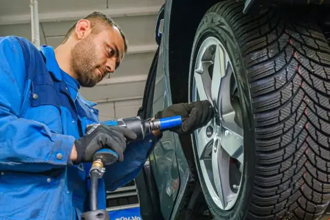 Mechaniker wechselt Winterreifen im Sommer. Mit dem richtigen Reifenwechsel sind Sie sicher unterwegs und Ihre Versicherung zahlt im Schadensfall.