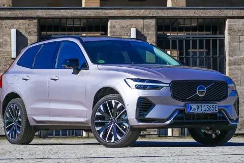 Ein silberner Volvo XC60 im Test, mit markantem Kühlergrill und LED-Scheinwerfern, steht vor einer Steinfassade.