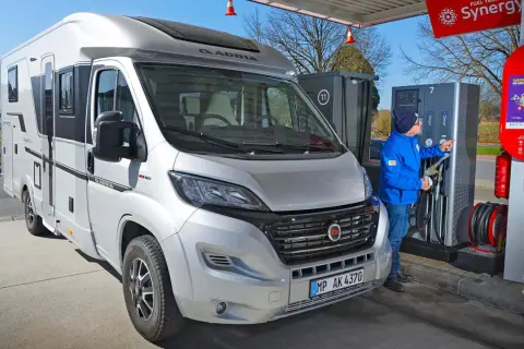 Mann tankt Wohnmobil an Tankstelle. Hoffentlich ist das Diesel nicht eingefroren bei der Kälte.