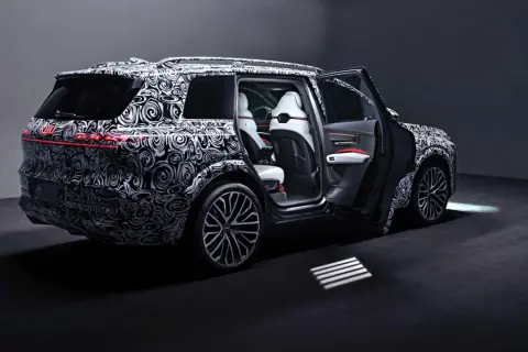 Der Audi SQ9, getarnt mit einem auffälligen Muster, zeigt seine luxuriösen weißen Ledersitze und die sportlichen Felgen.