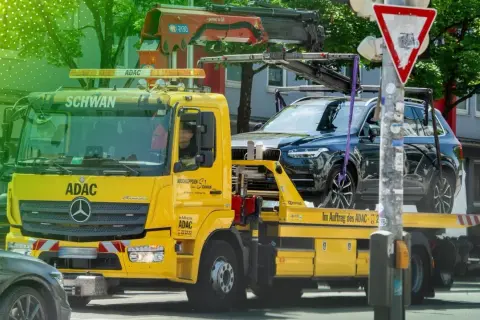 Gelber ADAC-Abschleppwagen mit SUV auf Ladefläche. Informiert über die Kosten eines Abschleppdienstes.