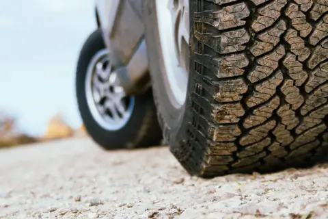 Detailaufnahme eines grobstolligen Offroadreifens, bereit für Abenteuer auf Schotterwegen.