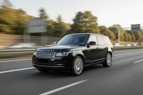 Schwarzer Range Rover fährt auf der Autobahn. Der kraftvolle Range Rover Motor surrt leise, während die Räder sich drehen.