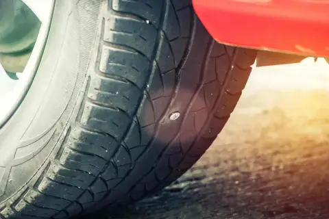 Ein Nagel steckt im Autoreifen. Zeit für einen auto reifen flicken, bevor die Luft entweicht.