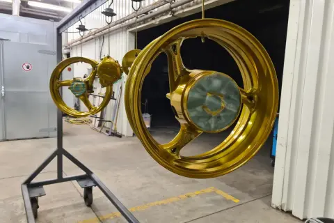 Goldene Felgen hängen zum Trocknen. Ein Prozess, der hilft, Felgen reparieren und ihnen neuen Glanz zu verleihen.