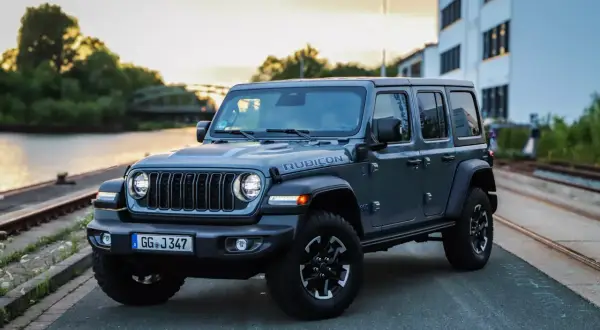 Grauer Jeep Wrangler Rubicon am Wasser, bereit für Abenteuer. Trotz seiner Robustheit gibt es auch Jeep Wrangler Schwachstellen zu beachten.