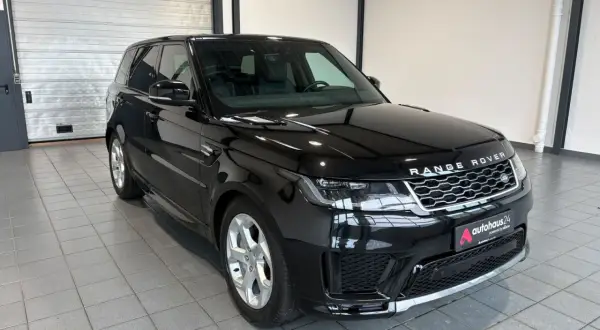 Schwarzer Range Rover Sport gebraucht Automatik mit silbernen Felgen steht in einer Garage.