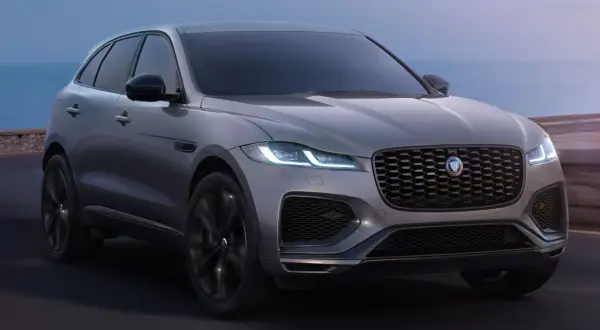 Grauer Jaguar F-Pace fährt am Meer entlang. Trotz seiner Eleganz gibt es manchmal Jaguar F-Pace Probleme.