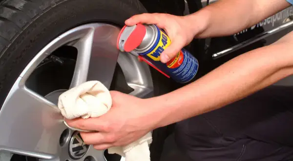 Person reinigt Felgen mit WD-40 und Tuch. Ein Hausmittel, das oft für felgen reinigen hausmittel verwendet wird.