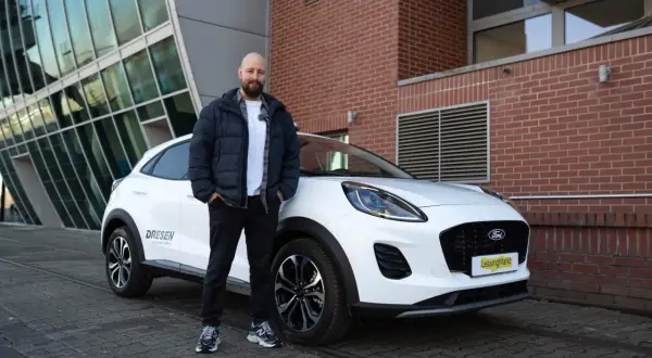 Mann steht neben weißem Ford Puma für einen Test.