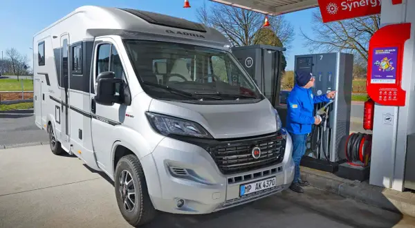 Mann tankt Wohnmobil an Tankstelle. Hoffentlich ist das Diesel nicht eingefroren bei der Kälte.