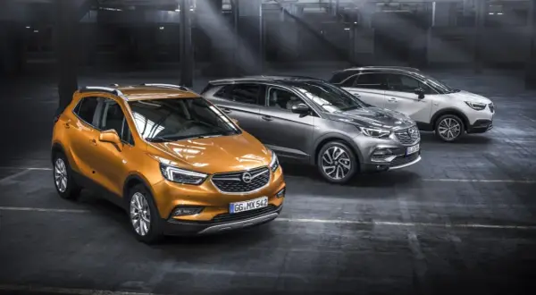 Drei Opel-Modelle in einem Parkhaus: ein orangefarbener Mokka, ein grauer Grandland X und ein weißer Crossland X. Ein Ausblick auf die Opel Modelle 2026.