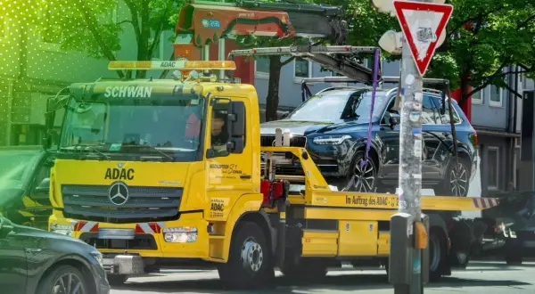 Gelber ADAC-Abschleppwagen mit SUV auf Ladefläche. Informiert über die Kosten eines Abschleppdienstes.