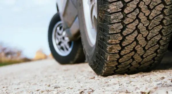 Detailaufnahme eines grobstolligen Offroadreifens, bereit für Abenteuer auf Schotterwegen.