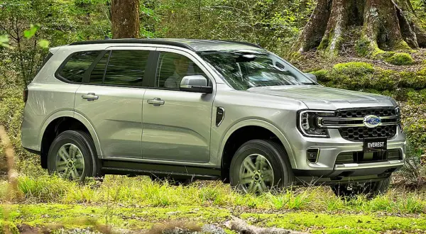 Silberner Ford Everest fährt durch grünen Wald in Deutschland.