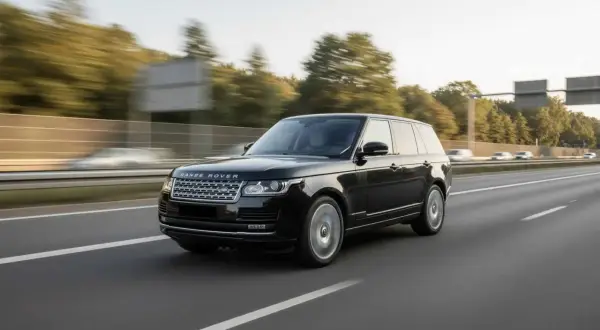 Schwarzer Range Rover fährt auf der Autobahn. Der kraftvolle Range Rover Motor surrt leise, während die Räder sich drehen.