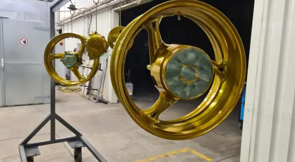 Goldene Felgen hängen zum Trocknen. Ein Prozess, der hilft, Felgen reparieren und ihnen neuen Glanz zu verleihen.